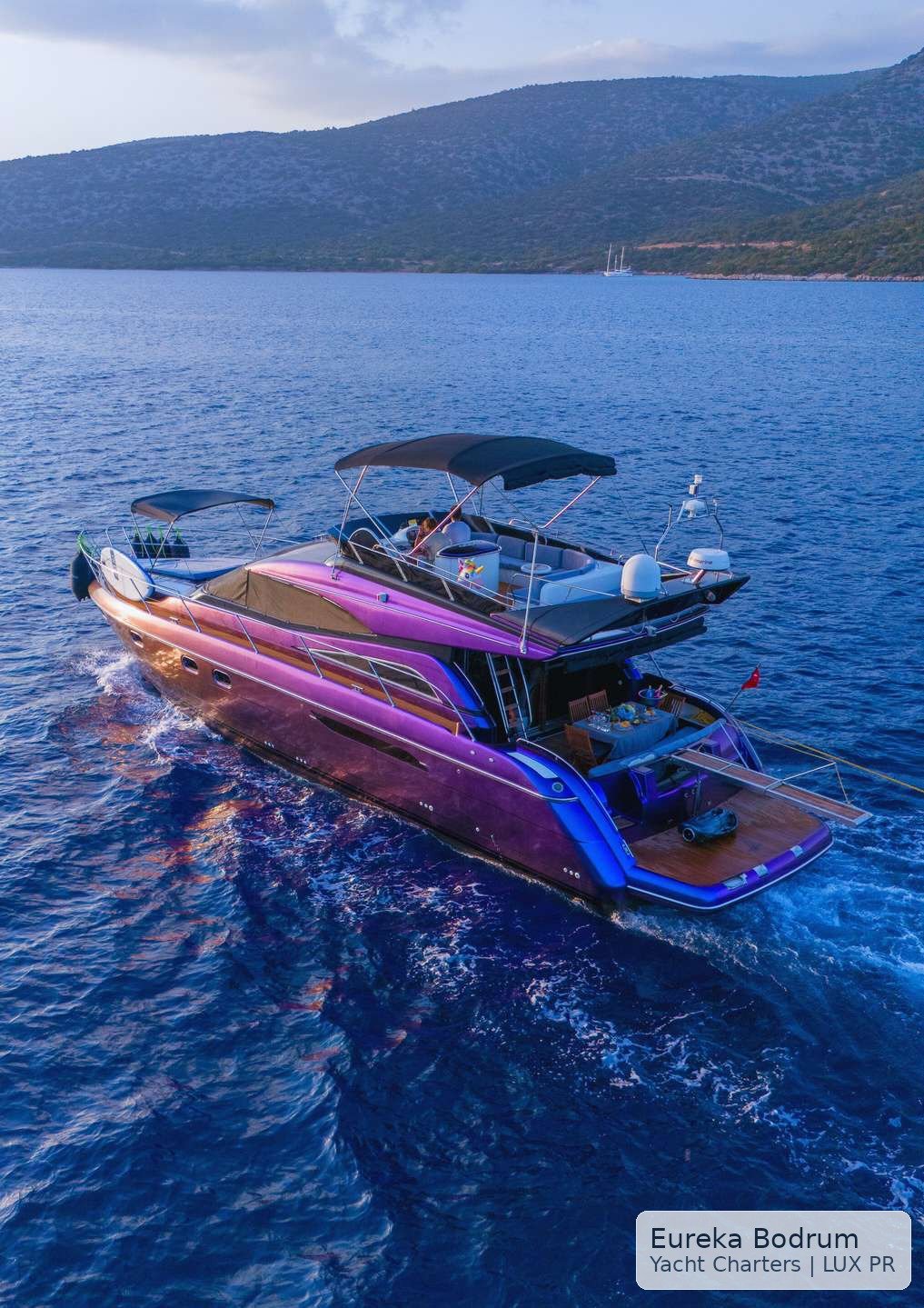 Aerial stern view of LUX PR cruising through blue Aegean water near Bodrum